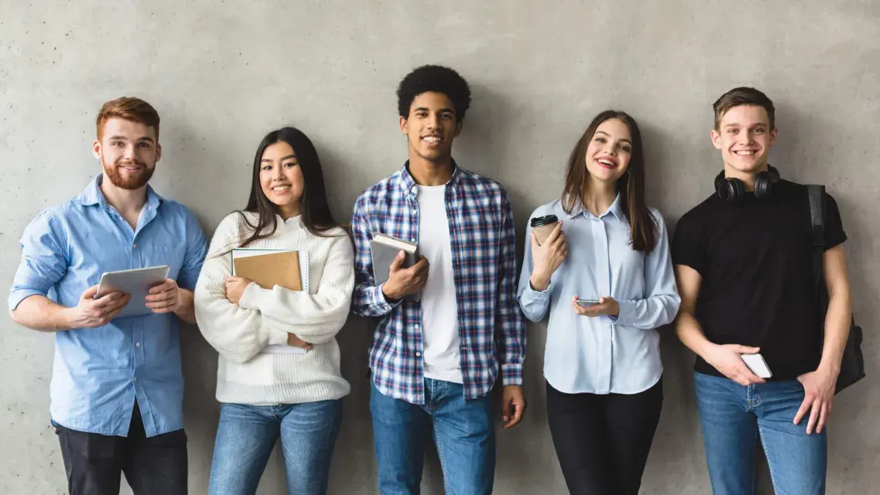 Cinq étudiants souriants, prêts pour leur grand oral STI2D. L'un tient une tablette, d'autres des livres.