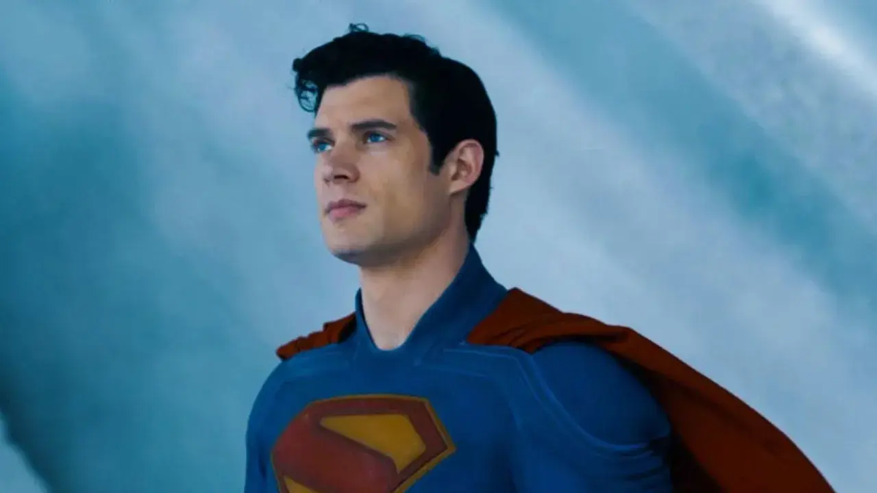 Superman, prénom de héros masculin, regarde au loin, son costume bleu et sa cape rouge flottant.