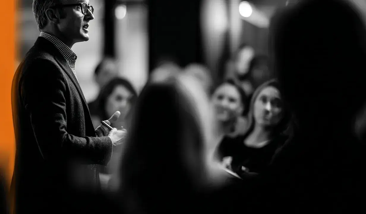 Un homme parle à une audience attentive. Je me souviens de cette conférence, c'était une expérience vécue marquante.