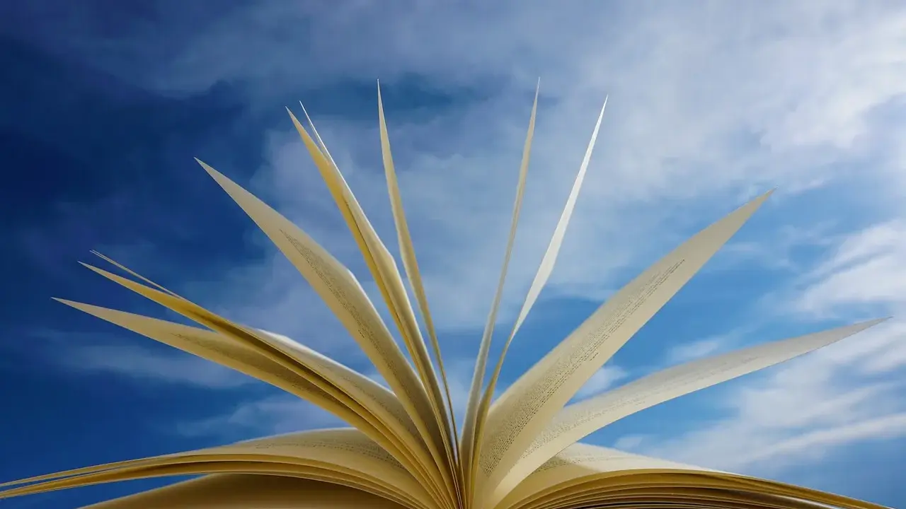 Un livre ouvert, ses pages s'envolent comme des oiseaux dans un ciel bleu. Un troisième exemple d'autobiographie, où chaque page raconte une nouvelle aventure.