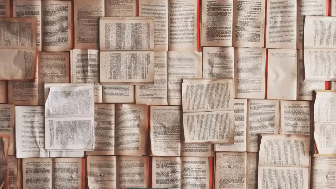 Un mur de livres ouverts, pages jaunies par le temps. Chaque page est une définition, un excipit de savoir.