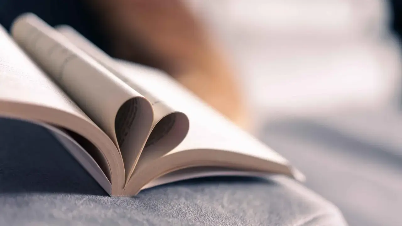 Un livre ouvert dont les pages forment un cœur, symbole de l'amour des mots et de la passion de la maison d'édition.