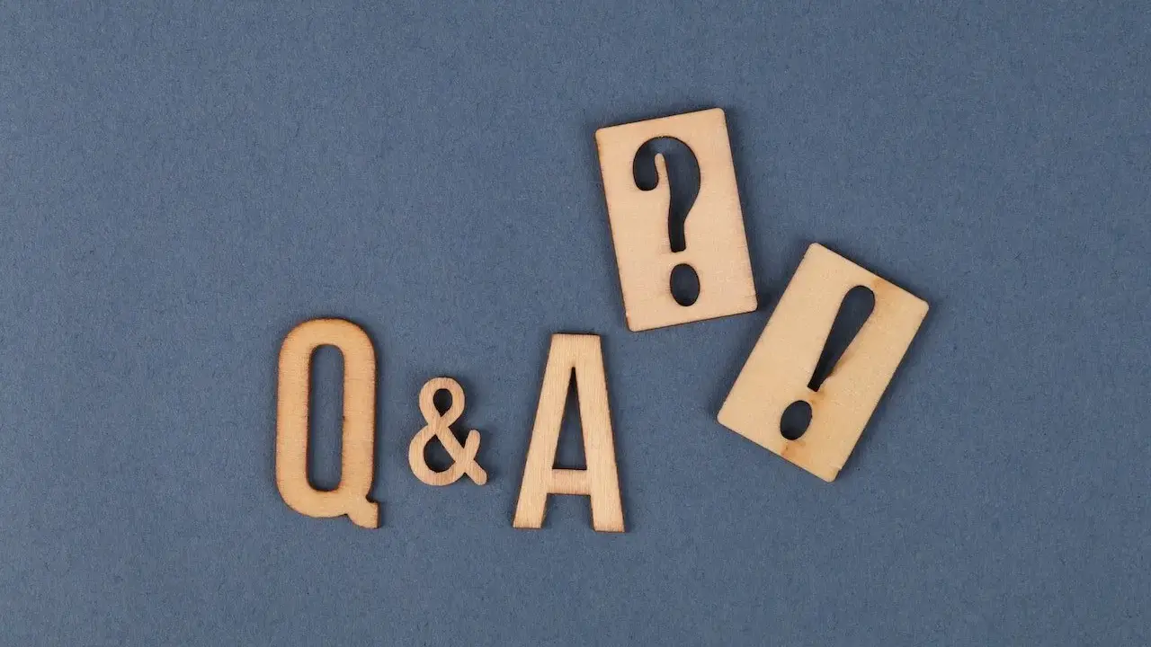 Lettres en bois "Q&A" avec un point d'interrogation et un point d'exclamation, symbolisant les questions de soutenance de mémoire.