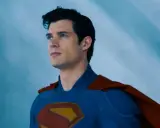 Superman, prénom de héros masculin, regarde au loin, son costume bleu et sa cape rouge flottant.