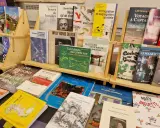 Des livres de divers éditeurs de livres, dont des ouvrages sur l'urbanisme, la photographie et la cuisine, sont exposés sur des étagères en bois.