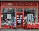La librairie La Page, une maison d'édition premier roman, expose ses livres et cartes postales en vitrine.