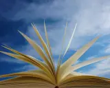 Un livre ouvert, ses pages s'envolent comme des oiseaux dans un ciel bleu. Un troisième exemple d'autobiographie, où chaque page raconte une nouvelle aventure.