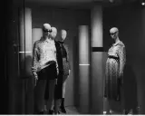 Mannequins dans une vitrine, avec un look nom americain stylé. L'une porte un pull à motifs et une jupe, l'autre une robe à imprimé serpent.