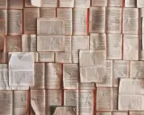 Un mur de livres ouverts, pages jaunies par le temps. Chaque page est une définition, un excipit de savoir.