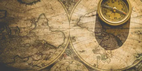 Une boussole dorée repose sur une carte ancienne du nom de monde imaginaire, projetant une ombre mystérieuse.
