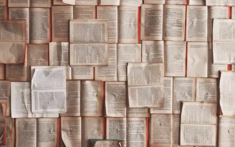 Un mur de livres ouverts, pages jaunies par le temps. Chaque page est une définition, un excipit de savoir.