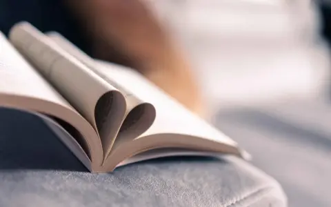 Un livre ouvert dont les pages forment un cœur, symbole de l'amour des mots et de la passion de la maison d'édition.