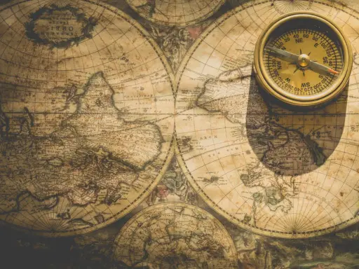 Une boussole dorée repose sur une carte ancienne du nom de monde imaginaire, projetant une ombre mystérieuse.