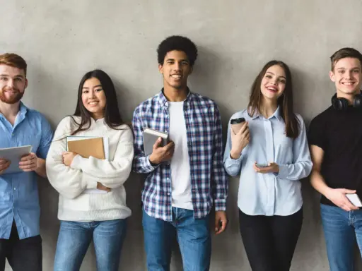 Cinq étudiants souriants, prêts pour leur grand oral STI2D. L'un tient une tablette, d'autres des livres.