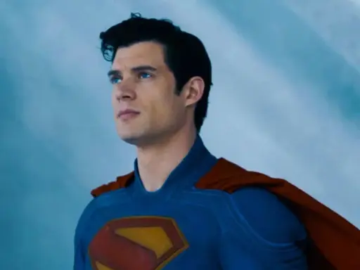 Superman, prénom de héros masculin, regarde au loin, son costume bleu et sa cape rouge flottant.