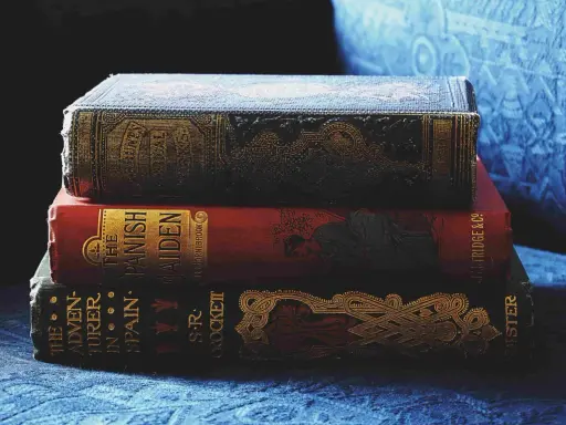 Pile de livres anciens aux couvertures ornées. Inspiré par ces reliures, découvrez comment créer la couverture d'un livre captivante.
