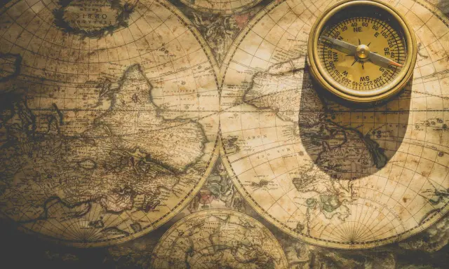 Une boussole dorée repose sur une carte ancienne du nom de monde imaginaire, projetant une ombre mystérieuse.