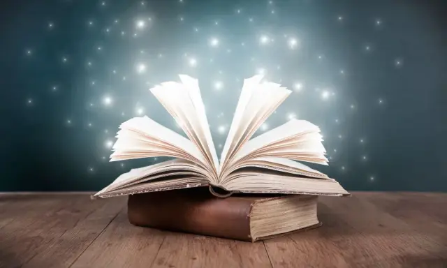 Un livre ouvert déploie ses pages lumineuses, comme un savoir universel. Un point de vue externe interne omniscient sur la magie des mots.
