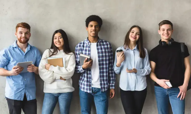 Cinq étudiants souriants, prêts pour leur grand oral STI2D. L'un tient une tablette, d'autres des livres.