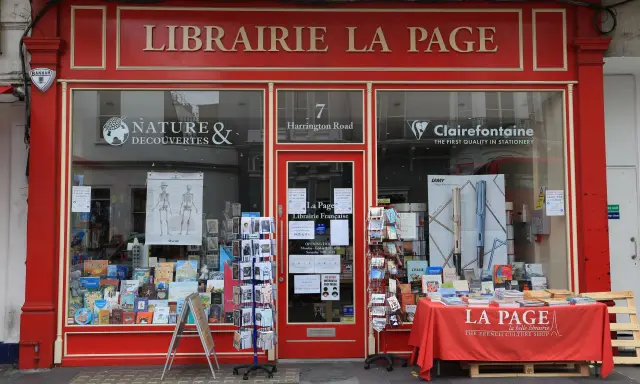 La librairie La Page, une maison d'édition premier roman, expose ses livres et cartes postales en vitrine.