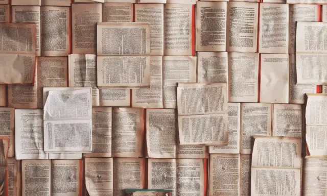 Un mur de livres ouverts, pages jaunies par le temps. Chaque page est une définition, un excipit de savoir.