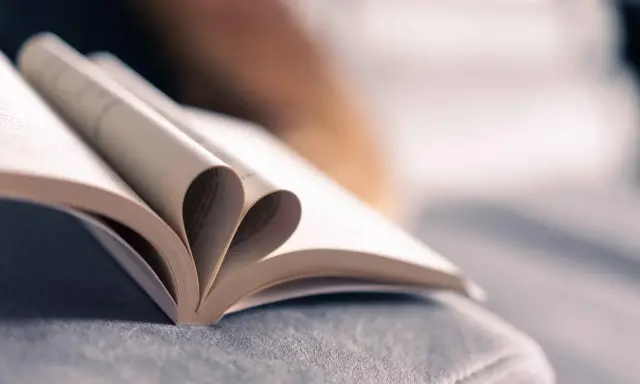 Un livre ouvert dont les pages forment un cœur, symbole de l'amour des mots et de la passion de la maison d'édition.
