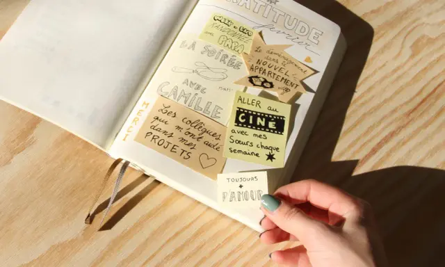 Un journal de gratitude avec des notes collées : "La soirée avec Camille", "Aller au cinéma avec mes sœurs", "Le déménagement dans le nouvel appartement".